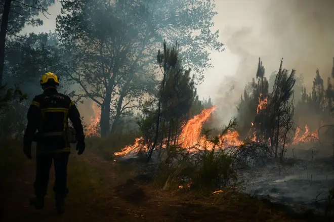 A firefighter battles a blaze near Landiras in Gironde, southwestern France