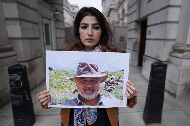 Roxanne Tahbaz, holds a picture of her father Morad Tahbaz outside the Foreign Office
