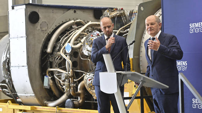 German Chancellor Olaf Scholz, right, stands beside Christian Bruch, chief executive of Siemens Energy, at the turbine serviced in Canada for the Nordstream 1 natural gas pipeline in Muelheim an der Ruhr, Germany