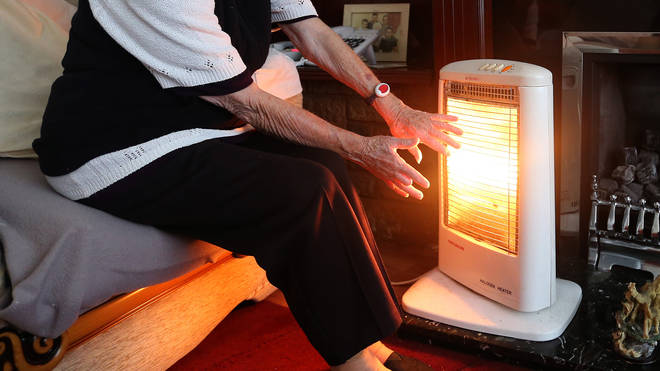 Old woman heats hands at fire