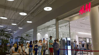 People line up to enter an H&M shop and buy items on sale in the Aviapark shopping centre in Moscow, Russia, on Tuesday August 9 2022