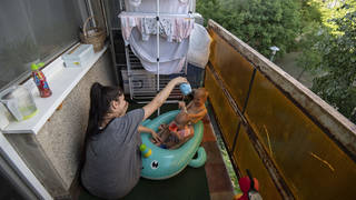 Krisztina plays with her children on their balcony in Budapest, Hungary