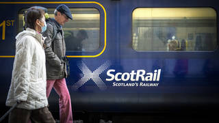 People walking past a ScotRail train