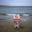 A sign reading 'swimming prohibited' on a beach in Marseille in southern France
