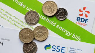 A close up of energy bills with money on top