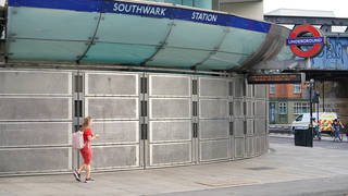 A woman walks past Southwark Station, closed due to strike action