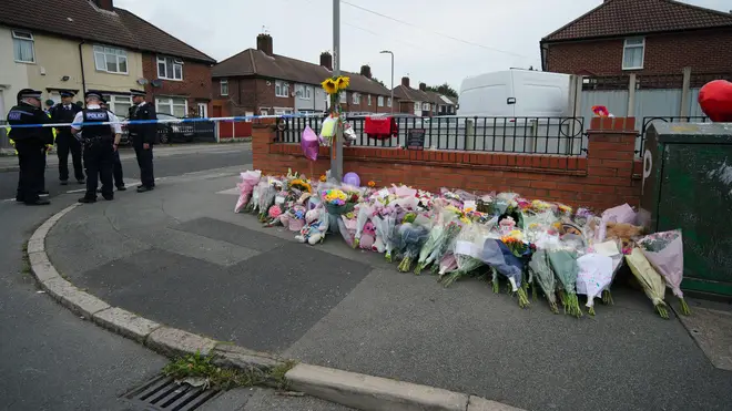 Flowers are left near to the scene of an incident in Kingsheath Avenue
