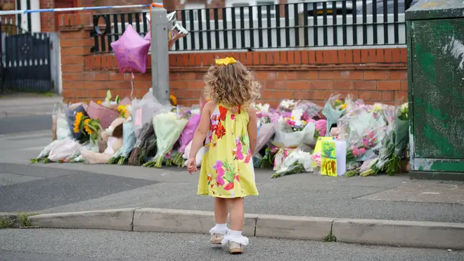 A young girl lays a tribute in Kingsheath Avenue