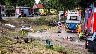 Emergency services operate at the scene of the accident after a lorry drove off a dike into a neighbourhood party