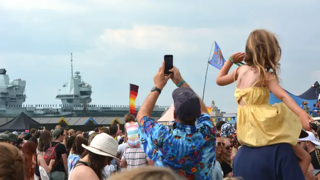 Festivalgoers give Royal Navy aircraft carrier HMS Prince of Wales a colourful send-off