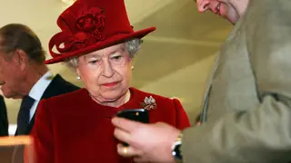 The Queen looks at a mobile phone