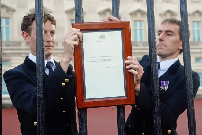 Members of royal household staff posts a notice on the gates of the Buckingham Palace in London announcing the death of Queen Elizabeth II.