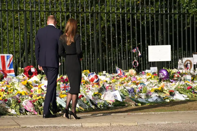 The Prince and Princess of Wales look at floral tributes laid by members of the public on the Long Walk at Windsor