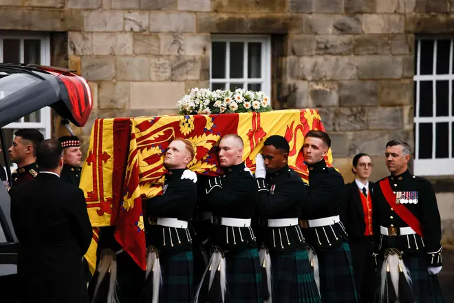 Pallbearers carrying the coffin of Queen Elizabeth II, draped with the Royal Standard of Scotland, as it arrives at Holyroodhouse, Edinburgh on Sunday where it will lie in rest for a day