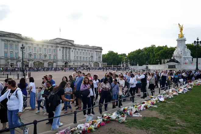 Visitors place flowers at Buckingham Palace