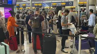 Passengers queue to check-in at Terminal 2 at Heathrow Airport, London