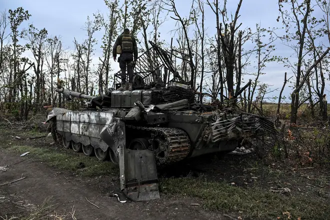 A Ukranian soldier standing atop an abandoned Russian tank near a village on the outskirts of Izyum, Kharkiv Region, eastern Ukraine