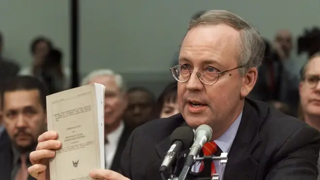 Ken Starr holds a document