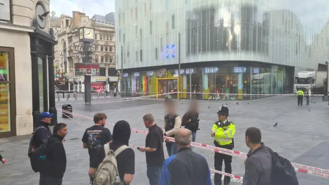 Members of the public and police at a cordon in Leicester Square this morning