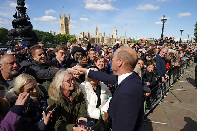 William shakes hands with well-wishers waiting to see his grandmother as she lies in state