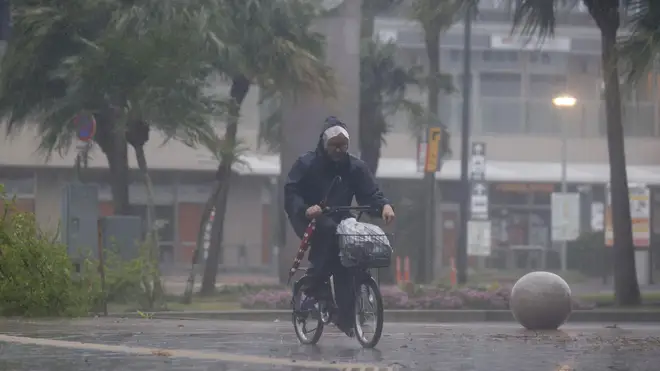 A man on a bicycle makes his way through the rain in Miyazaki, southern Japan