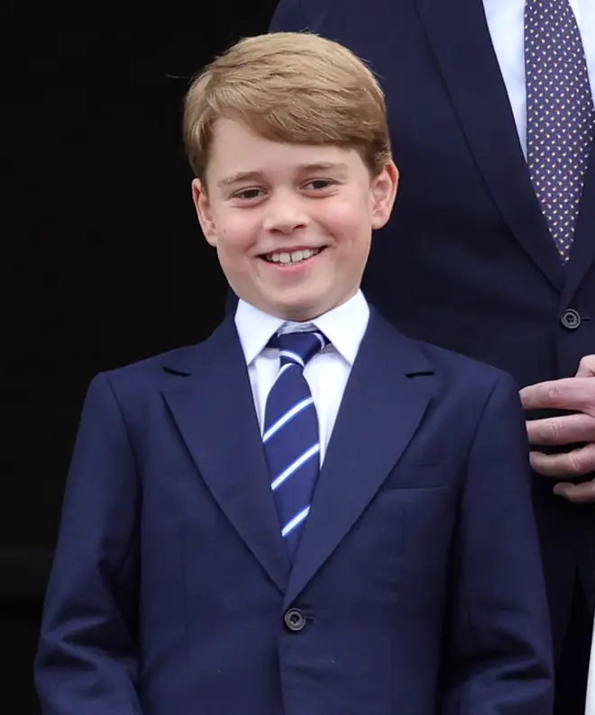 Prince George wearing navy suit and smiling
