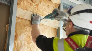 A builder installing insulation