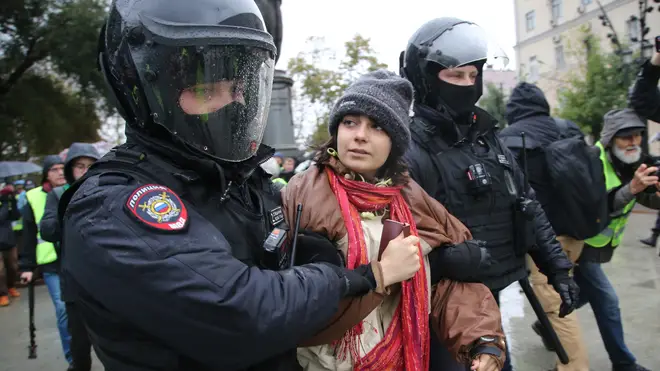 Police officers detain a woman during the unsanctioned rally hosted by the Vesna