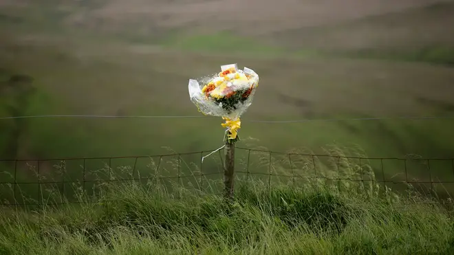 Floral tributes overlook Saddleworth Moor where the body of missing Keith Bennett may be buried