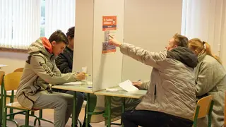 Latvians mark their ballots at a polling station in Riga