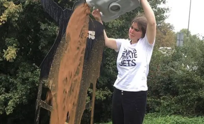 The activist carries out her dirty protest on the statue of Sir Tom Moore