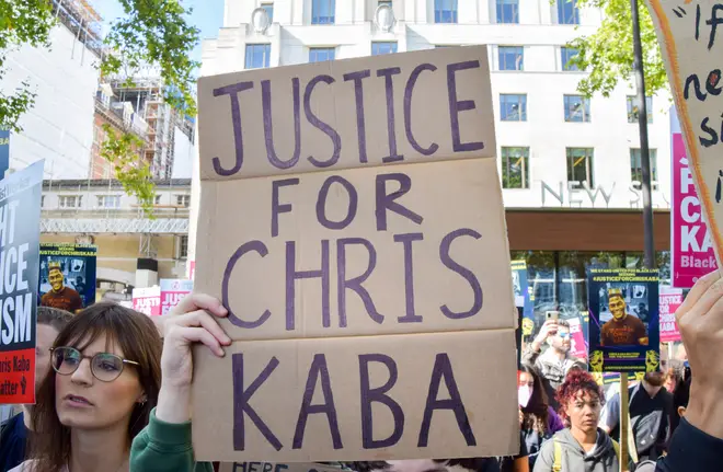 A protester holds a "Justice for Chris Kaba" placard