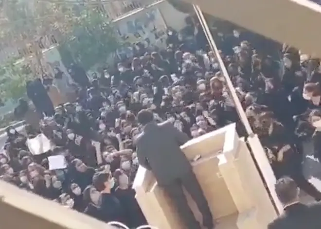 A group of Iranian school girls heckle a member of Iran's feared paramilitary Basij force.