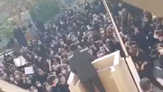 A group of Iranian school girls heckle a member of Iran's feared paramilitary Basij force.