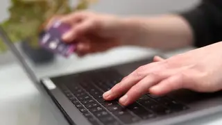 Someone using a laptop and bank card