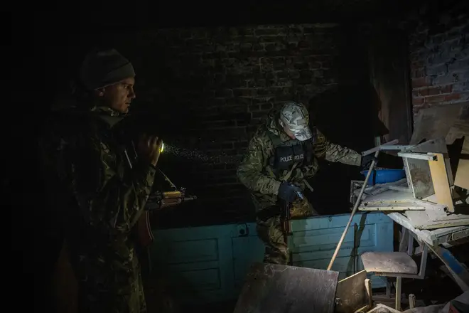 Eleven Russian troops were shot dead. Pictured - Ukrainian troops searching an abandoned Russian stronghold