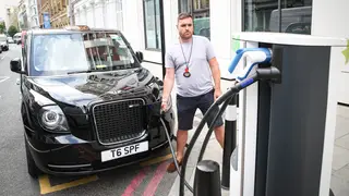 A cabbie charges his black cab at one of the few charging points in central London