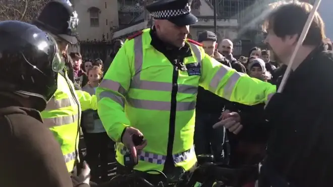 Police officers try to deal with the motorcyclist and protesters