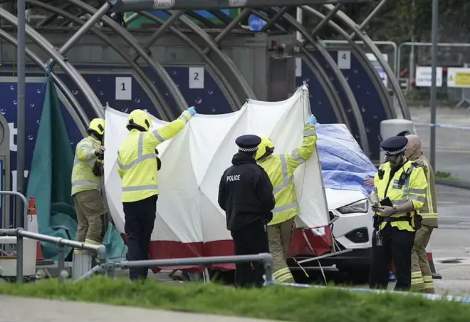 Police officers with the car allegedly used by the suspect