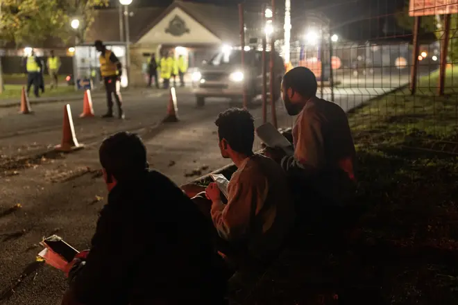 Three men sit at the Manston processing centre