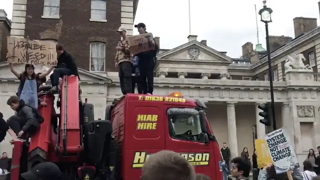 The moment students on strike climb onto the roof of a lorry which became stuck in climate change protests in central London
