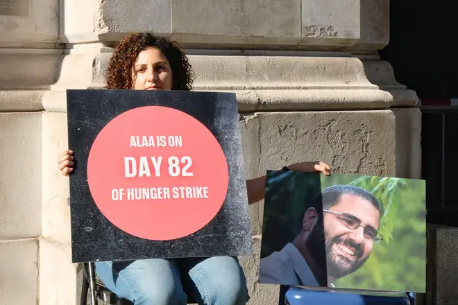 Mona Seif holds a photo of her brother outside the Foreign Office in June.