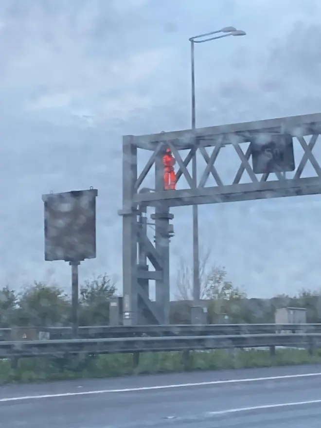A protester climbs a gantry at junction 27
