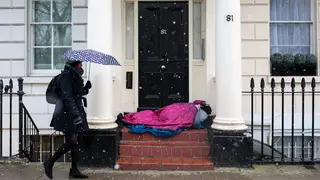 A homeless person sleeps in the snowy weather in London
