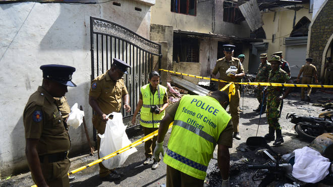 Police look through debris outside Zion Church following an explosion on Easter Sunday