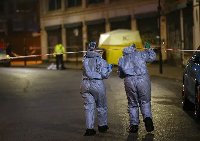 Police forensic officers at the scene of a stabbing.