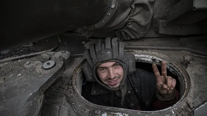 A Ukrainian soldier shows V sign from a tank as Ukrainian troops continue toward Kherson