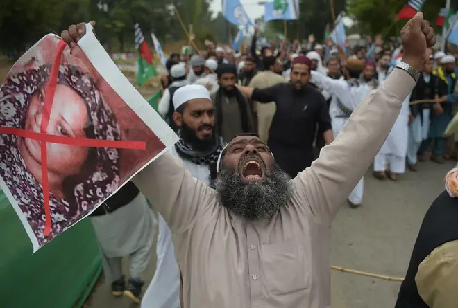 A supporter of the Ahle Sunnat Wal Jamaat (ASWJ), a hardline religious party, holds an image of Christian woman Asia Bibi during a protest rally.