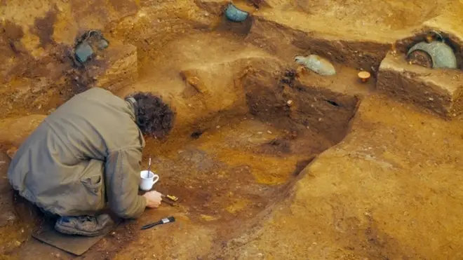 Archaeologists examine the tomb.