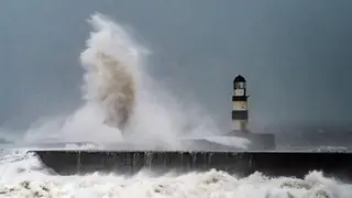 Waves crash against the lighthouse in Seaham Harbour, County Durham